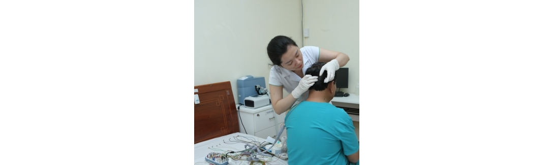 Kỹ thuật viên gắn máy đa ký giấc ngủ cho bệnh nhân