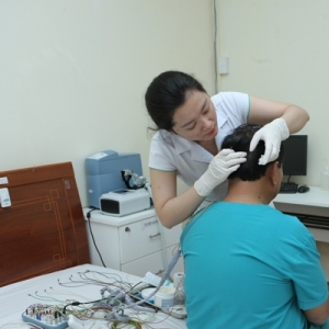 Kỹ thuật viên gắn máy đa ký giấc ngủ cho bệnh nhân